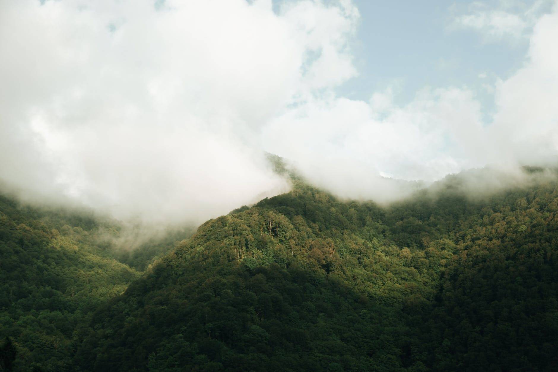 green mountains with thick white clouds